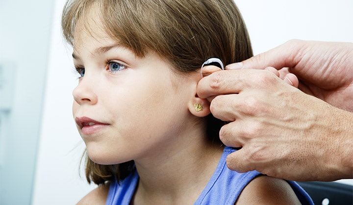 Doctor putting an earhorn in a child's ear